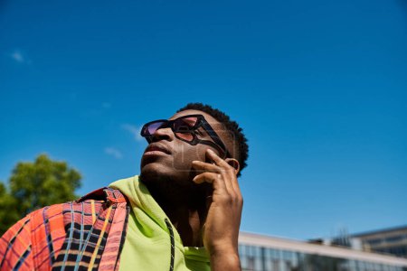 Foto de Joven hombre negro en gafas de sol posando activamente. - Imagen libre de derechos