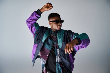 Photo for Stylish African American man in purple jacket and sunglasses dancing energetically. - Royalty Free Image