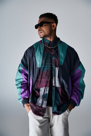 Foto de Young handsome man in vibrant jacket and shades, exuding style. - Imagen libre de derechos