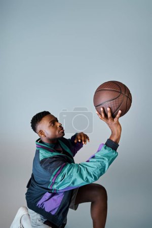 Un hombre afroamericano con estilo atrapa una pelota de baloncesto con habilidad y precisión.