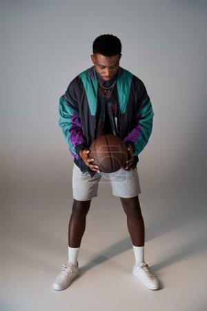 Photo for Fashionable young man holding basketball in front of white background. - Royalty Free Image