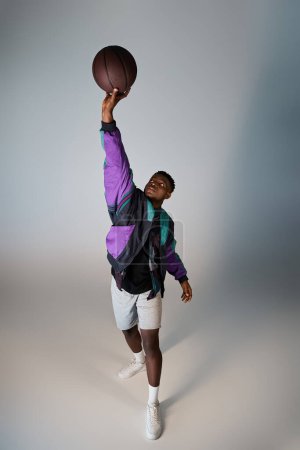 Photo for A stylish African American man holding a basketball. - Royalty Free Image