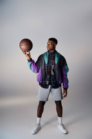 Foto de Hombre afroamericano guapo en traje de moda sosteniendo un balón de fútbol. - Imagen libre de derechos