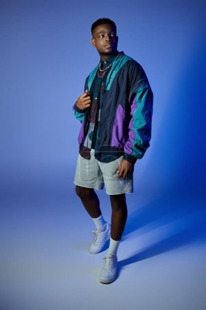 El hombre afroamericano de moda posando en una chaqueta colorida.
