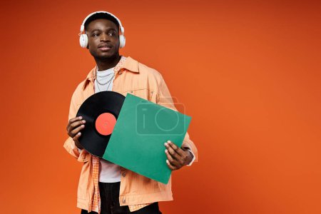 Jeune homme noir élégant tenant un disque vinyle.