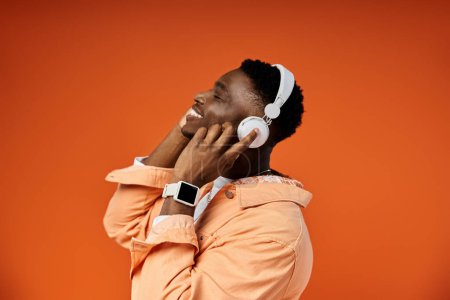 Young African male enjoys music with headphones.