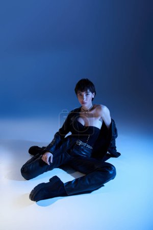 Téléchargez les photos : A beautiful young woman poses actively in stunning black leather attire. - en image libre de droit