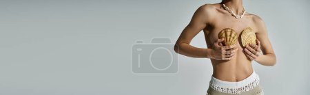 Téléchargez les photos : A stylish young woman holding shells gracefully. - en image libre de droit