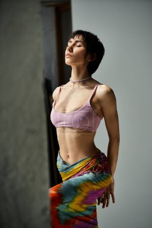 Téléchargez les photos : A young woman in a colorful bikini striking a pose. - en image libre de droit