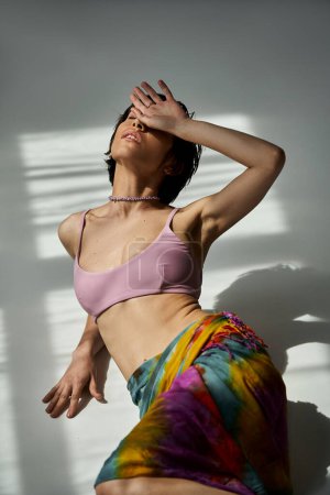 Téléchargez les photos : Stylish woman striking a pose in a colorful, vibrant skirt. - en image libre de droit