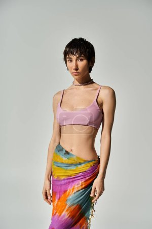 Foto de Young woman in colorful tie dye skirt posing confidently for a shot. - Imagen libre de derechos