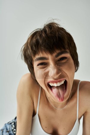 Young woman playfully sticking out her tongue.