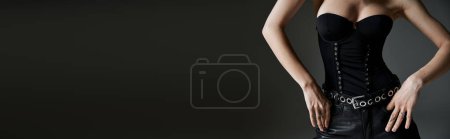 Téléchargez les photos : A beautiful young woman strikes a pose in a stylish black corset. - en image libre de droit