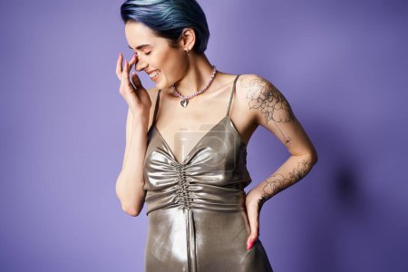 A young woman with blue hair strikes a pose in a stunning silver dress