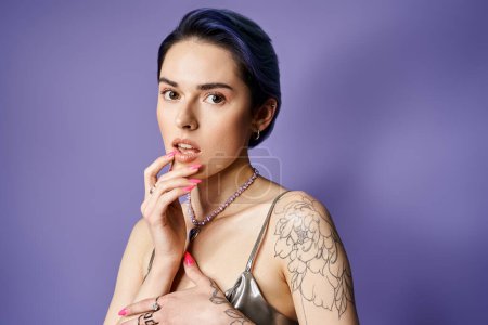 Téléchargez les photos : A woman, adorned with tattoos on her arms and chest, exudes confidence and individuality in a studio setting. - en image libre de droit