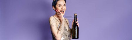 Young woman with short blue hair elegantly holds a bottle of champagne in a silver party dress, exuding sophistication.