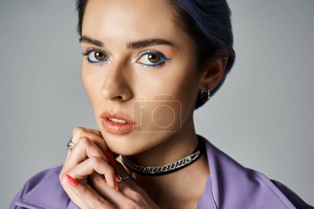 A style-forward girl with blue hair striking a pose in a fashionable choker.