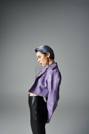 A vibrant young woman with unique short hair poses in a purple jacket and black pants in a trendy studio setting.