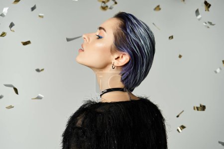 A young woman with eye-catching blue hair stands confidently in front of a backdrop of confetti.