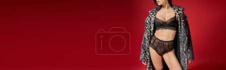 Foto de A young woman sensually poses in lingerie and a leopard print coat. - Imagen libre de derechos