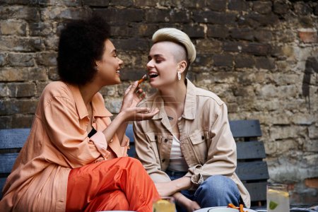 Foto de Two diverse, beautiful lesbians enjoying a coffee date in a stylish cafe. - Imagen libre de derechos