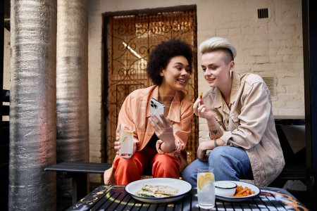 Téléchargez les photos : Un beau couple diversifié de lesbiennes partageant un moment dans un café. - en image libre de droit