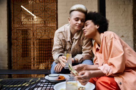 Téléchargez les photos : Deux femmes profitent d'un repas ensemble à une table dans un cadre confortable. - en image libre de droit