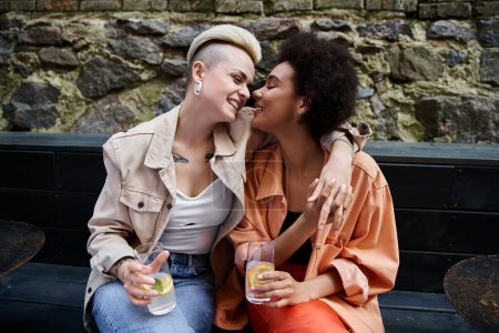 Two women enjoying a date on a bench.