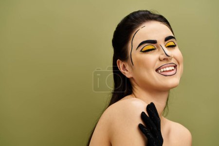 Femme brune au maquillage pop art et aux yeux jaunes saisissants regarde mystérieusement, portant des gants noirs.