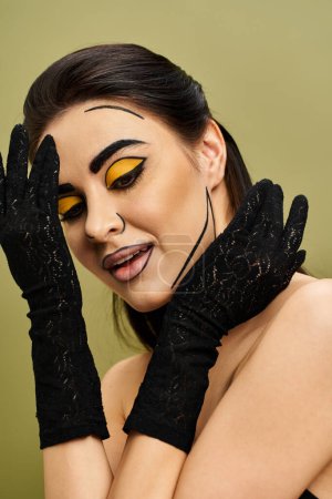 Brunette woman with pop art makeup in black gloves exudes mystery and allure.