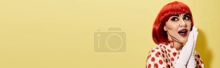 Téléchargez les photos : Une rousse créative en maquillage pop art tient une serviette sur fond jaune. - en image libre de droit