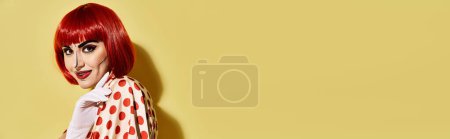 Téléchargez les photos : Une jolie rousse au maquillage pop art créatif portant une robe à pois sur fond jaune, inspirée des BD. - en image libre de droit