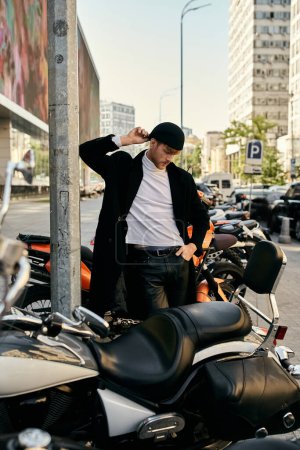 Hombre pelirrojo en traje de debonair de pie junto a la motocicleta estacionada.