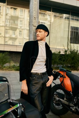 Red-haired man in debonair attire standing next to parked motorcycle.