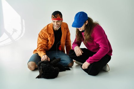 A gay couple and their furry companion sit peacefully on the ground.