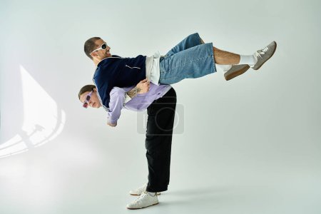 A man confidently handstands on another man, showcasing strength and trust.