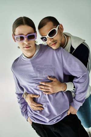 Photo for Two young men in purple shirts and sunglasses posing together. - Royalty Free Image
