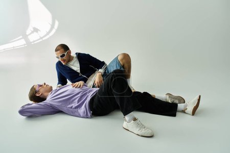 Un beau couple gay allongé sur le sol, partageant du temps de qualité ensemble.
