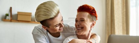 Photo for Lesbian couple in volunteer shirts embrace, women hug - Royalty Free Image