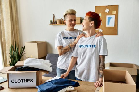 Two women in volunteer t-shirts working together in a room.