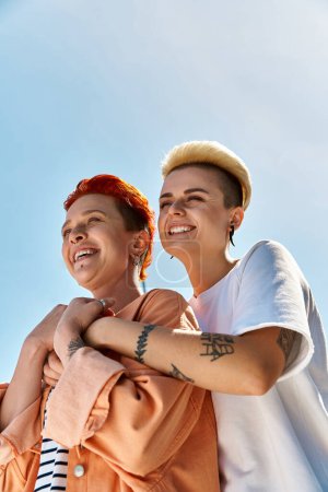 Una joven pareja de lesbianas se mantiene unida, celebrando el amor y la pertenencia a la comunidad LGBTQ.