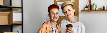 Una joven pareja de lesbianas se encuentra unida en un centro de voluntariado rodeado de cajas, encarnando la unidad y el apoyo.