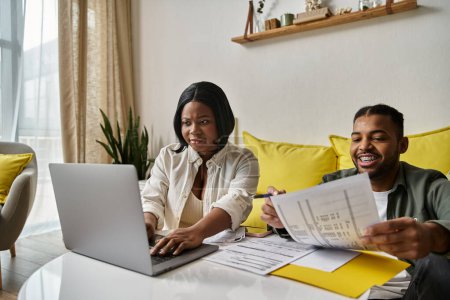 An African American couple works together on their finances at home.