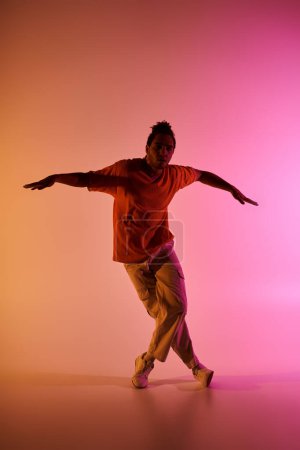 Ein junger Afroamerikaner tanzt ausdrucksstark vor lebendigem Hintergrund.