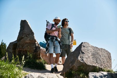 Two young men, a gay couple, hike together through a rocky wilderness area on a sunny summer day.