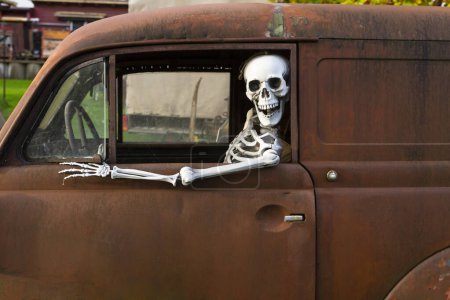 Téléchargez les photos : Squelette humain assis dans une vieille voiture rouillée et regardant par la fenêtre - en image libre de droit