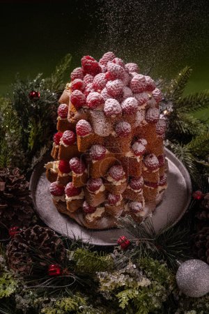 Photo for Christmas raspberry decorated Italian sweet bred Pandoro (pan d'oro) dusted with icing sugar on green background - Royalty Free Image