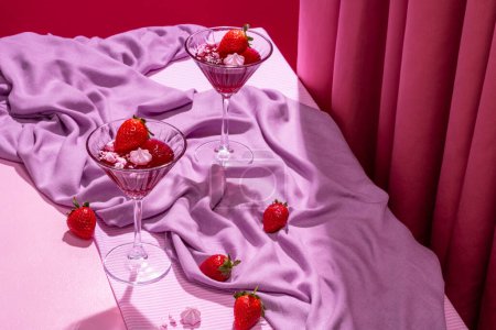 Foto de Postre de merengue y jalea de fresa en vidrio alto decorado en una romántica escena rosa - Imagen libre de derechos