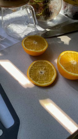 Vier Orangen halbiert auf einem Schneidebrett. Perfekt für kulinarische Blogs, gesunde Lifestyle-Webseiten oder Social-Media-Posts über frische Produkte.