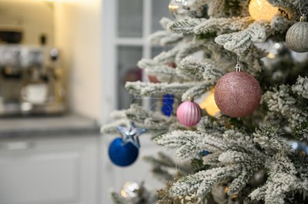 Photo for Decorated Christmas tree branch closeup at blurred kitchen background - Royalty Free Image